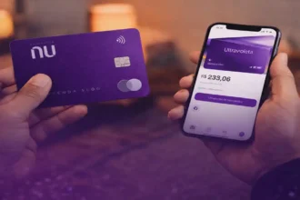 Cartão Nubank Ultravioleta sendo segurado junto com celular exibindo aplicativo financeiro
